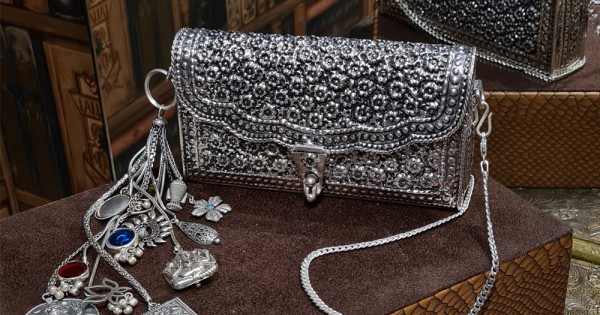 What materials are commonly utilized in silver designer handbags and purses?